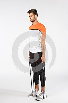 Full-length focused, motivated handsome sportsman in activewear, shorts, t-short and sports leggings, stand on