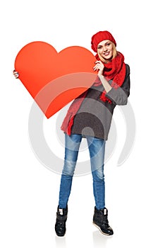 Full length girl holding up a red cardboard heart