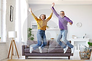 Full length of happy active energetic senior caucasian family couple jumping and having fun together