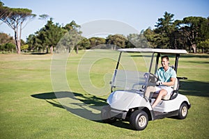 Full length of happy golfer man driving golf buggy