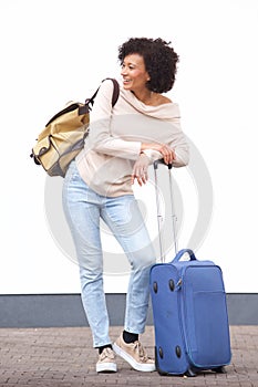 Full length happy travel woman standing by white wall