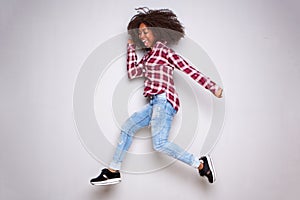 Full length happy young african woman jumping over white background