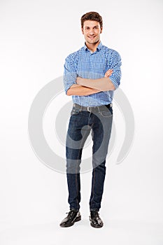 Full length of happy young man standing with arms crossed