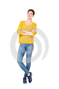 Full length happy young woman standing with arms crossed against isolated white background