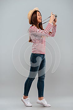 Full length image of cheerful asian woman in sweater
