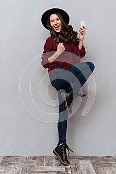 Full length image of cheerful brunette woman in sweater