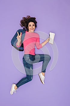 Full length image of european woman 20s in casual clothing wearing backpack running with paper notes in hand