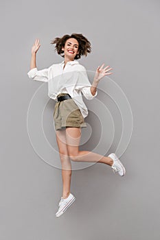 Full length image of european woman 20s smiling and jumping, iso