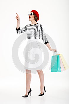 Full length image of ginger woman in sunglasses with packages