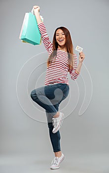 Full length image of Happy asian woman in sweater rejoice
