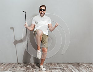 Full length image of a Happy Screaming golfer in sunglasses