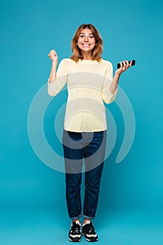 Full length image of Happy woman in sweater rejoice