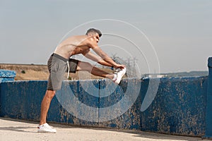 Full length image young male jogger warmimg up