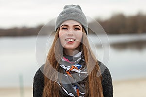 Full length lifestyle portrait of young and pretty adult woman with gorgeous long hair posing in city park with shallow depth of f