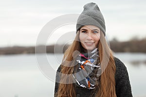 Full length lifestyle portrait of young and pretty adult woman with gorgeous long hair posing in city park with shallow depth of f