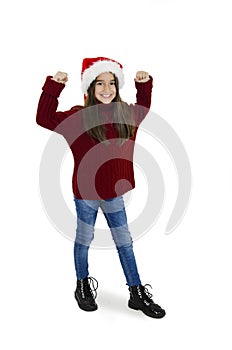 Full length of little girl in red Santa hat with hands up. Christmas little girl.