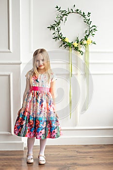 Full-length of little smiling girl child in colorful dress posing indoor