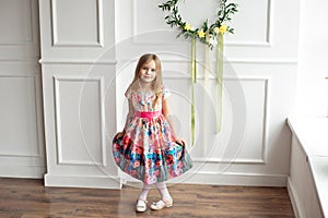 Full-length of little smiling girl child in colorful dress posing indoor