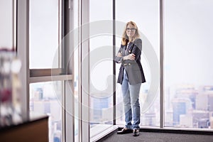 Mid aged businesswoman wearing business casual and standing in the office