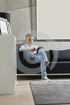 Full-length of Middle-aged man using tablet PC on sofa