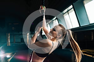 Full length narrow angle shot of a woman with climbing rope. Copyspace background with athletics healthy composition