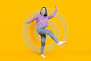 Full length photo of adorable funky lady dressed purple shirt dancing having fun isolated yellow color background