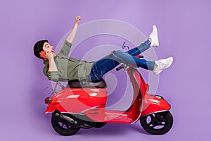 Full length photo of amazed brunette man winner rider wear jeans phone talk crazy isolated on purple color background