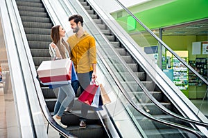 Full length photo of attractive lady handsome guy couple spend free time carry many bags moving up escalator shopping