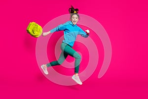 Full length photo of attractive young lady wear blue sweater holding schoolbag jumping running isolated pink color