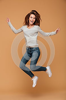 Full length photo of charming young woman in casual wear jumping