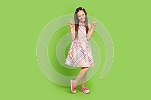 Full length photo of cheerful adorable girl wear stylish clothes sarafan demonstrate v-sign empty space isolated on