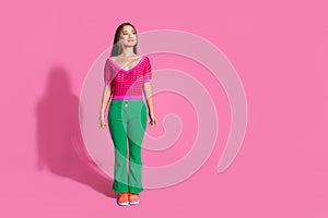 Full length photo of cheerful dreamy lady dressed knitted shirt walking loking empty space isolated pink color