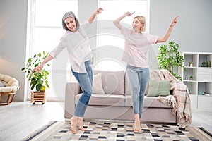 Full length photo of cheerful funky young woman and old lady dance point finger indoors inside house home