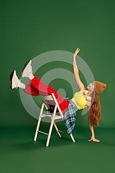 Full-length photo of cheerful girl wearing stylish clothes having fun over green background. Youth fashion