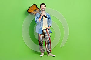 Full length photo of cheerful good mood guy dressed jeans shirt enjoying guitar music empty space isolated green color