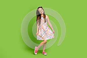 Full length photo of cheerful pretty carefree girl wear sarafan hand touch dress good mood isolated on green color
