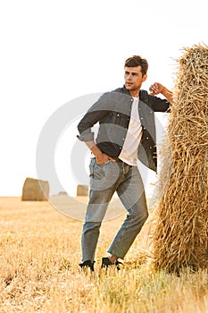 Full length photo of countryside man 30s walking through golden