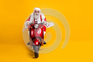 Full length photo of crazy funky santa claus in red hat drive motorcycle ride fast hurry to x-mas noel celebration wear