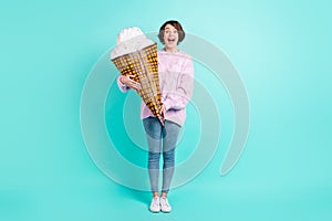 Full length photo of cute excited young woman wear violet sweater holding huge ice cream isolated turquoise color