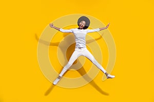 Full length photo of dark skin happy woman jump up star shape smile isolated on yellow color background