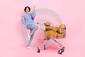 Full length photo of delighted excited person raise fists success buy pumpkin isolated on pink color background