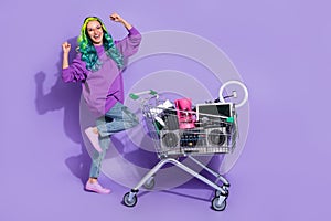 Full length photo of excited lady with vivid hairdo fist up swap vintage stuff isolated over violet color background