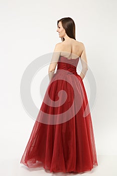 Full length photo of fashion model woman wearing elegant evening dress red gown posing isolated on white wall background