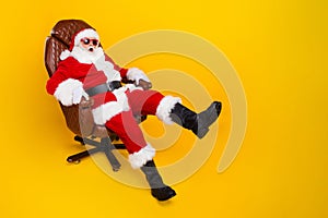 Full length photo of fooling funny santa claus costume pensioner man riding armchair at new year party isolated on
