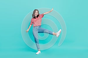 Full length photo of funky charming lady wear striped t-shirt dancing having fun smiling isolated turquoise color