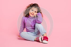 Full length photo of funky charming little child dressed purple pullover sitting floor smiling  pink color