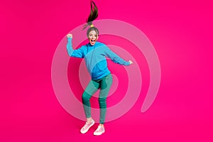 Full length photo of funky excited woman dressed blue hoodie dancing hands arms fists isolated vibrant pink color