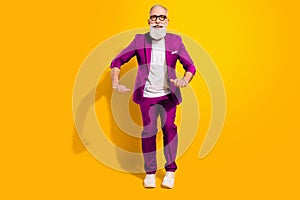 Full length photo of funky funny happy old man dance good mood smile wear shoes isolated on yellow color background