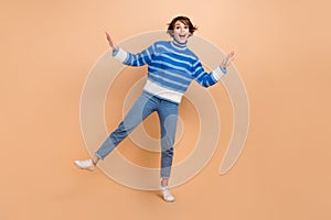 Full length photo of funky pretty woman dressed striped sweater having fun dancing isolated beige color background