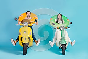 Full length photo of funky two people lady guy drive retro moped good mood spread legs crazy hold colorful life buoys